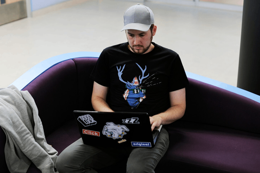 Man in a printed T-shirt reading about the cost of DTF printing.